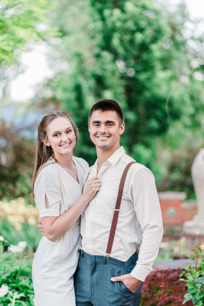 A young couple in neutral clothing smile for their Colorado springs engagement photos to capture their love