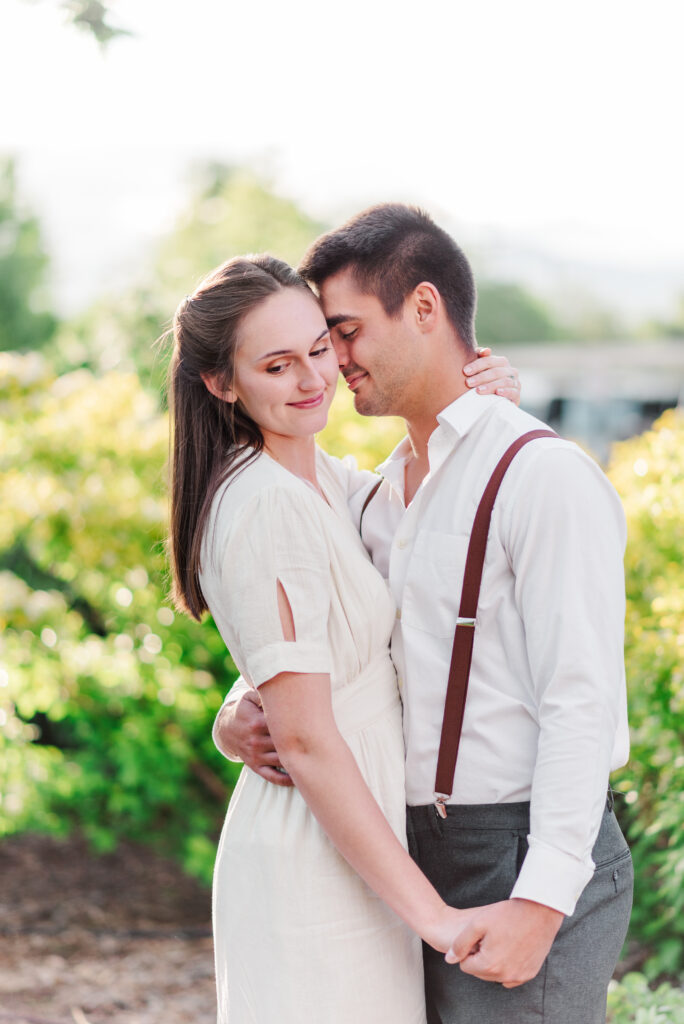 Close up image of two young people nuzzling near a glowy bush for Denver wedding photographerDenver wedding photographer